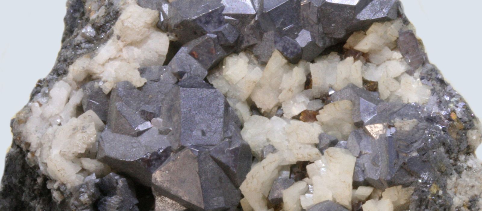 Fotografía de cristales de galena, el mineral del que se extrae el plomo, de color gris metálico y forma cúbica, junto a cristales blancos de dolomita, procedentes de la mina de Áliva, en los Picos de Europa (Cantabria)