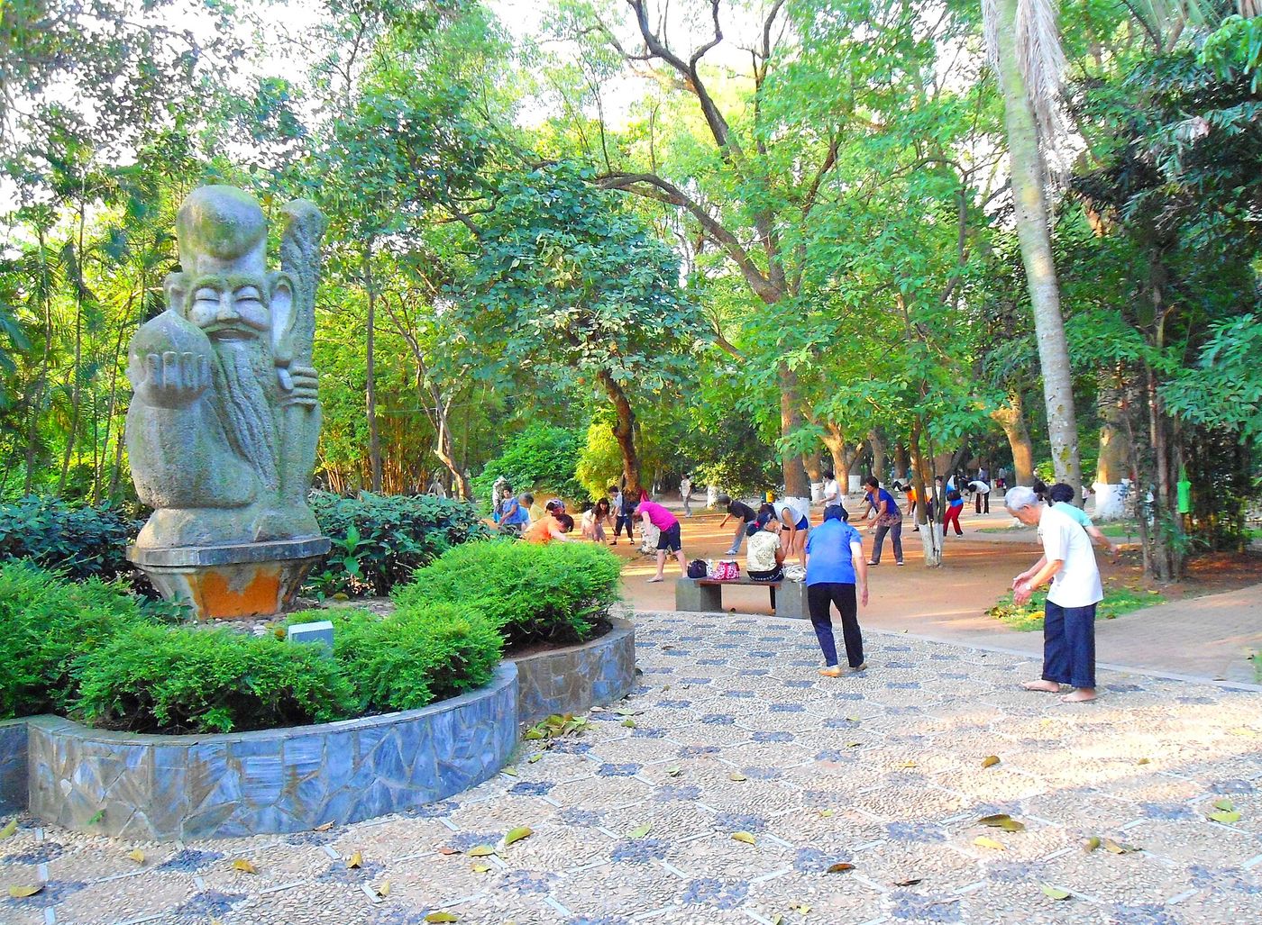 Personas haciendo ejercicio en un parque público, algunas estirando y otras caminando
